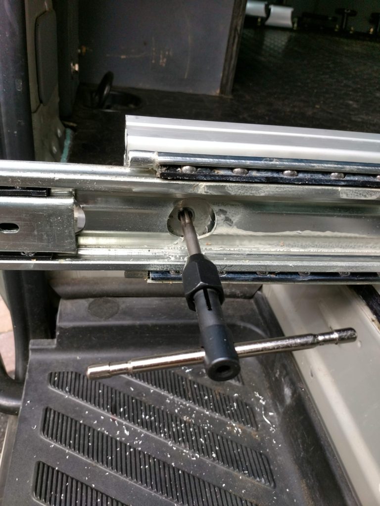 Tapping threads into the 8020 to attach the slide for the kitchen